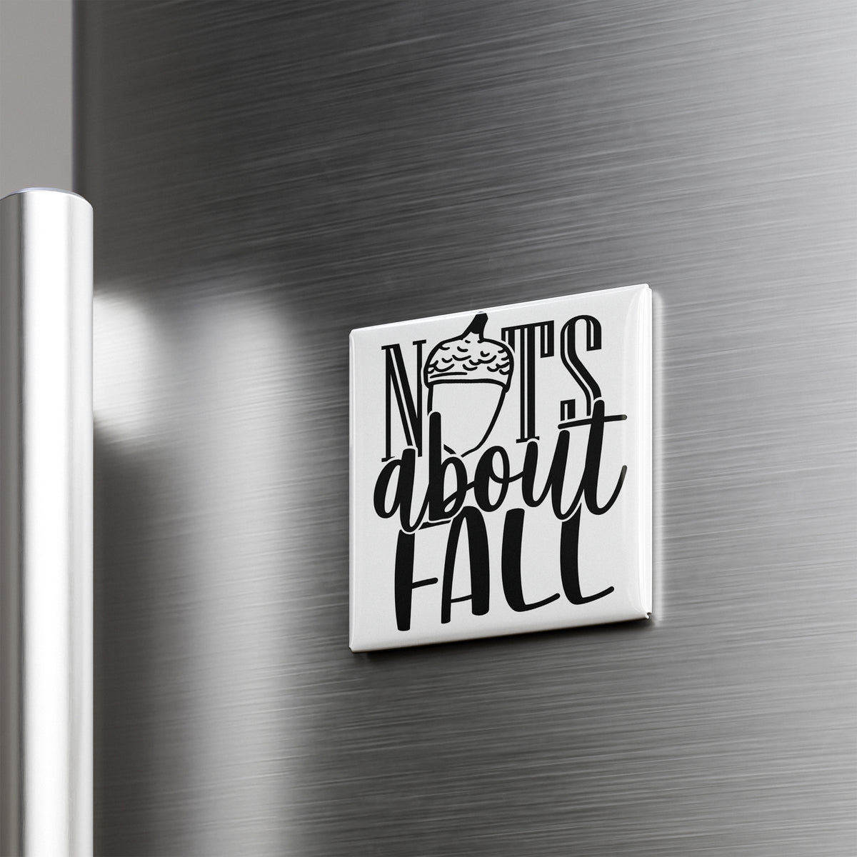 A white square magnet with the text "NOTS ABOUT FALL" on it, which is mounted on a metallic surface.
