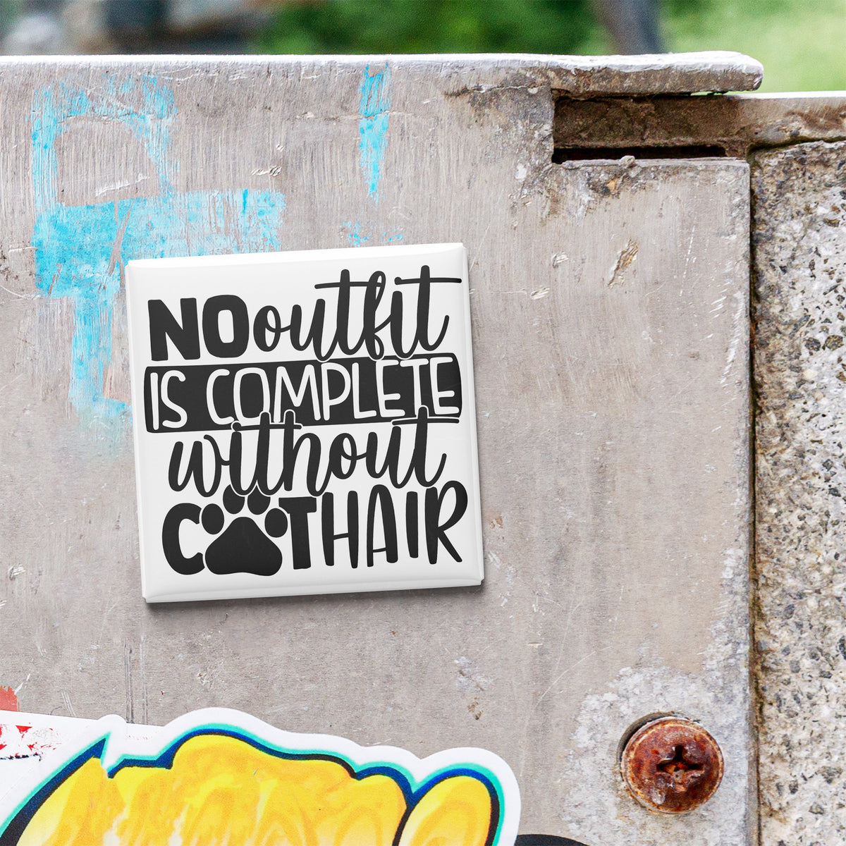 a sticker with the text "NO OUTLIT IS COMPLETE without COOTHAIR" on a concrete surface.