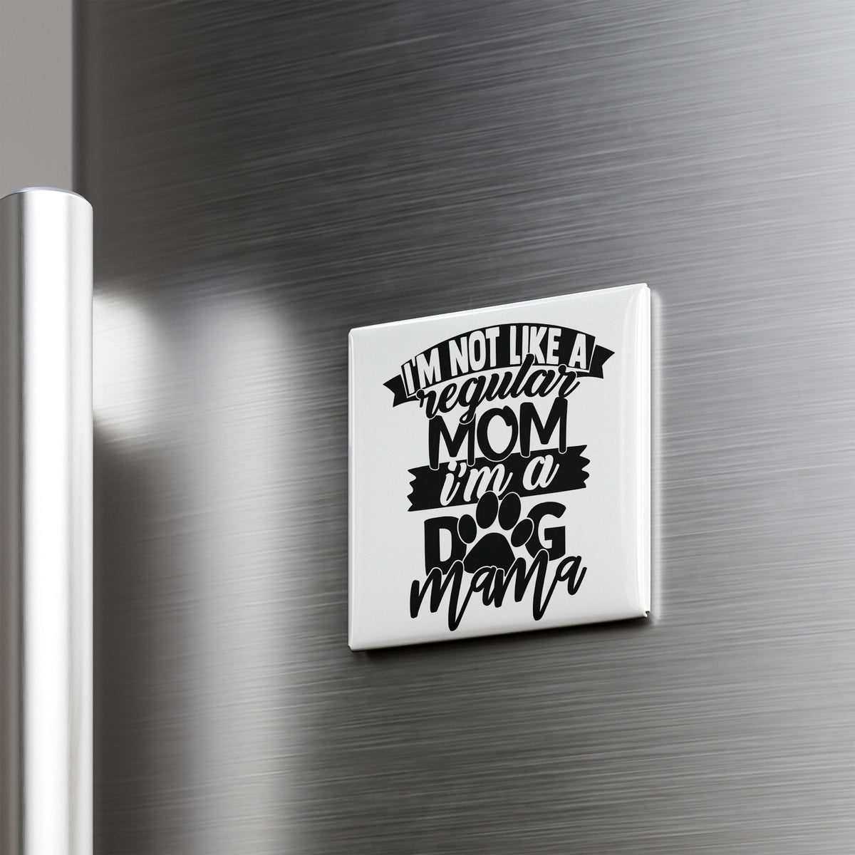 A humorous fridge magnet with the text "I'M NOT LIKE A REGULAR MOM I'M A DOG MAMA" printed on it.