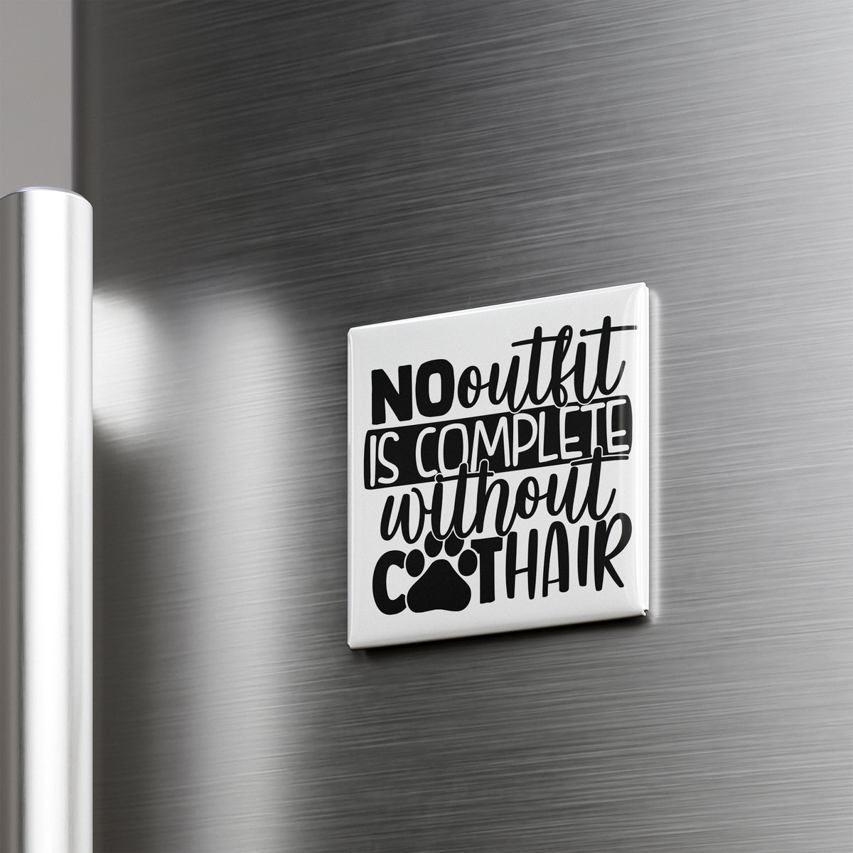 a white square magnet with black text on it, which reads "NO outfit is complete without hair".