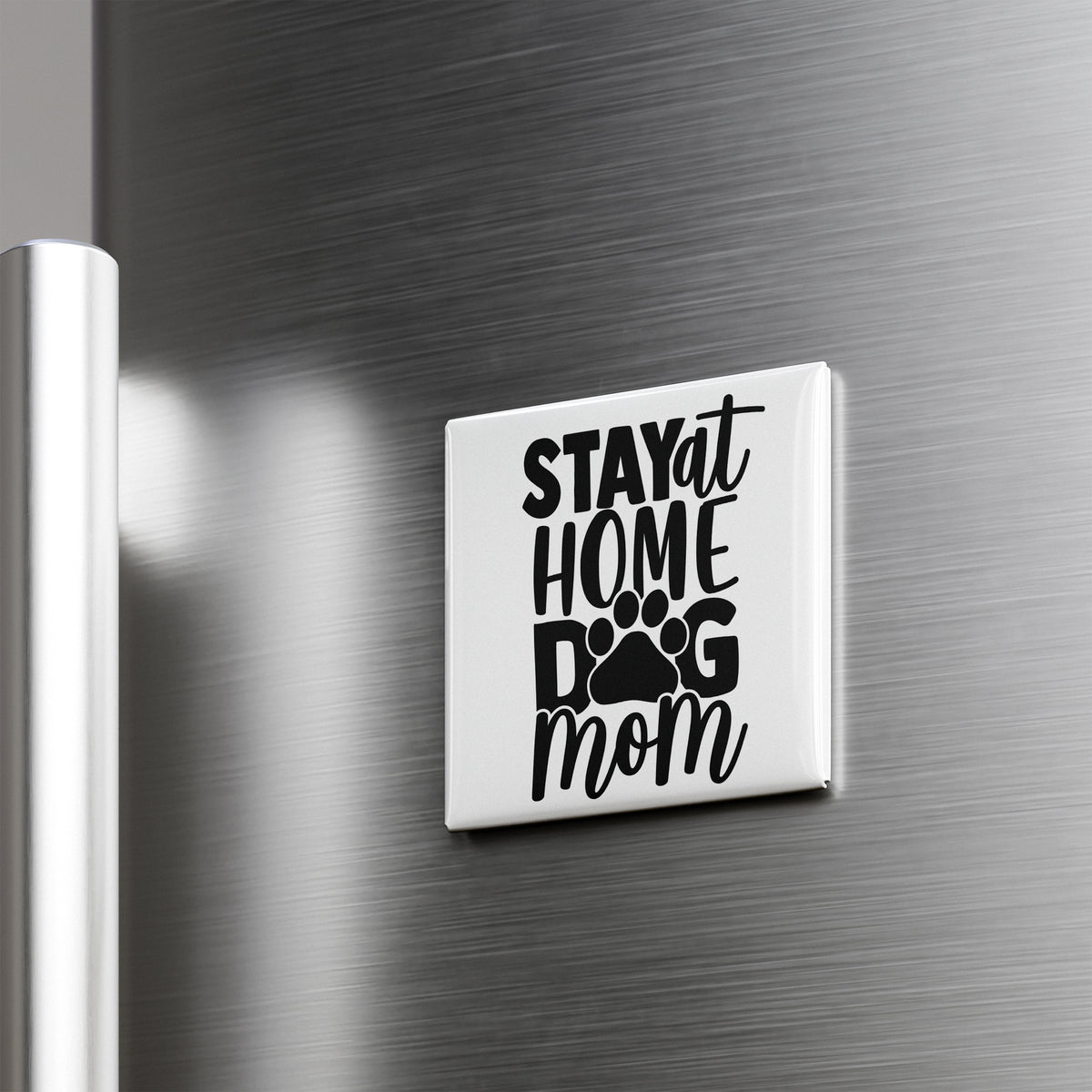 A white refrigerator magnet with the text "STAY AT HOME DOG MOM" printed on it.