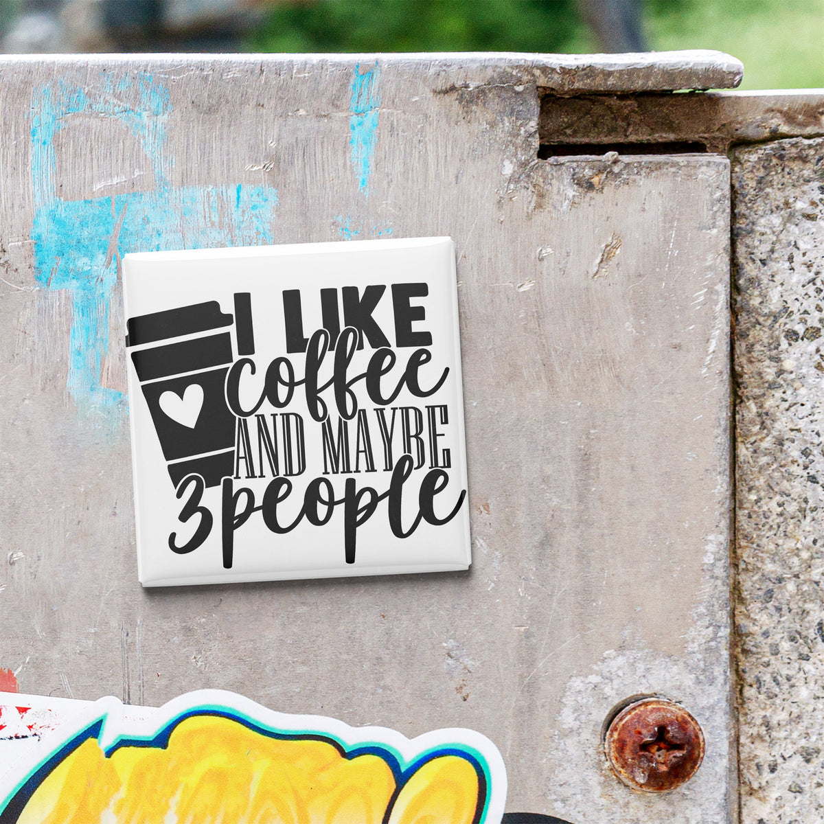 a sticker with the text "I LIKE coffee AND MAYBE 3 PEOPLE" on a concrete surface.