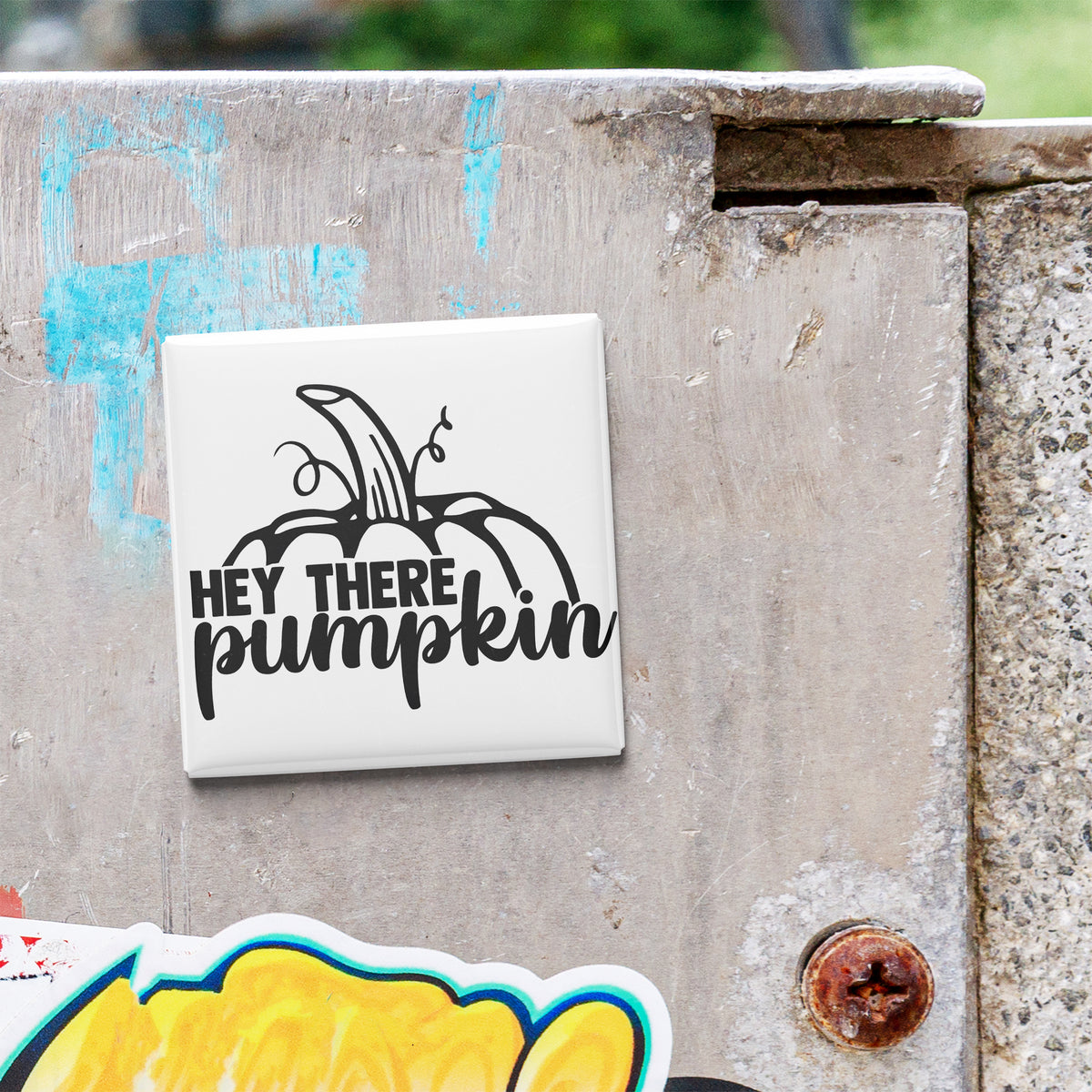 a white square tile with a black graphic and text that says "HEY THERE PUMPKIN" on a gray wall.