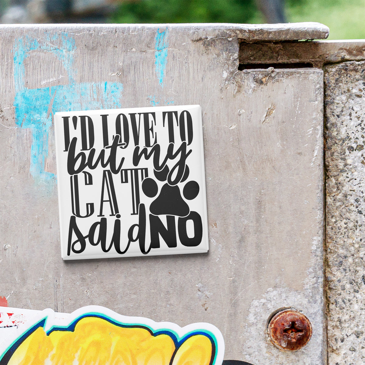 A sticker with the text "I'd love to but my cat said no" is attached to a concrete wall.