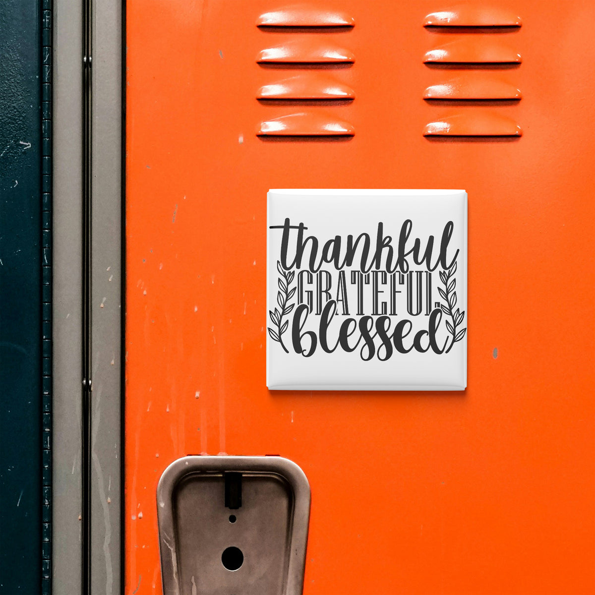 a bright orange wall with a white sign that says "Thankful Grateful Blessed" in black text.