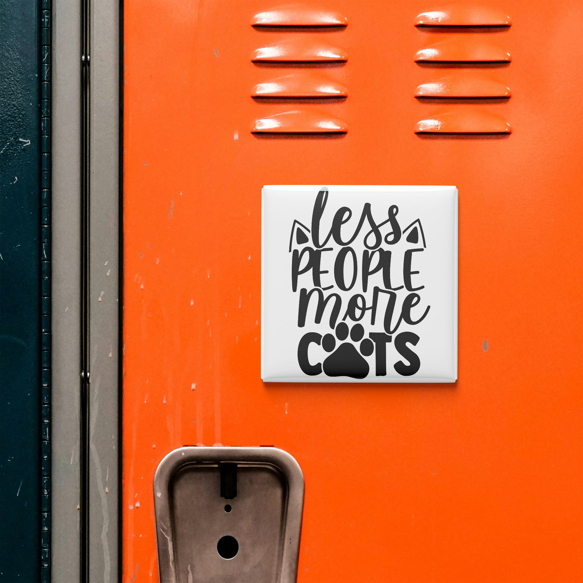 a sign with the text "less people more cats" on an orange surface, with a small metal object below it.