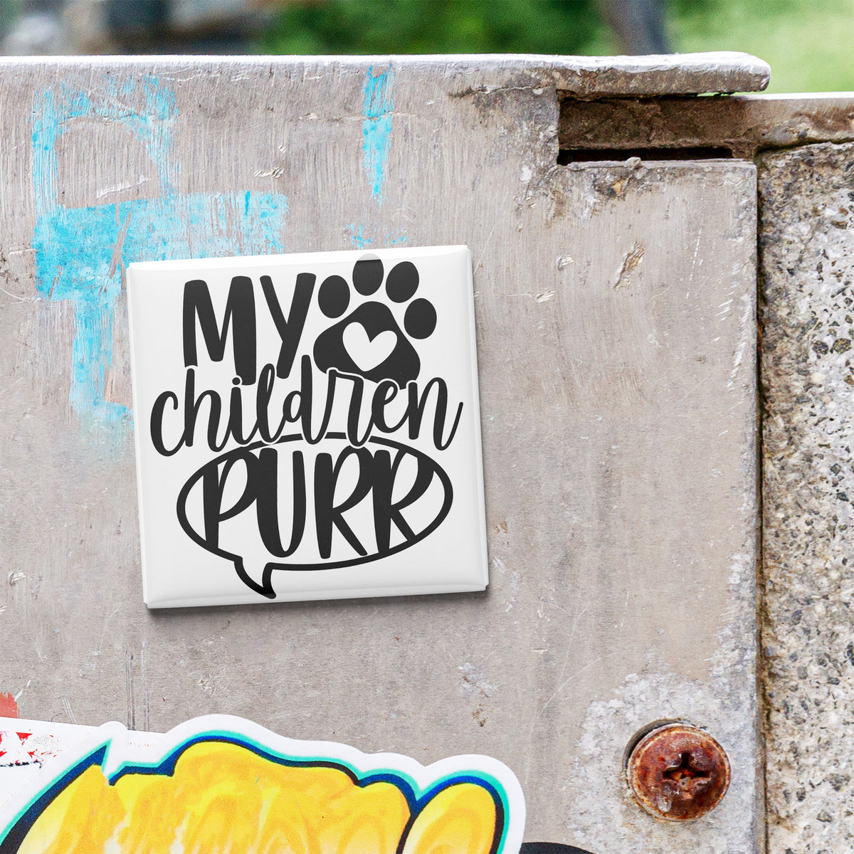 A sticker with the text "My children purr" is attached to a concrete surface.
