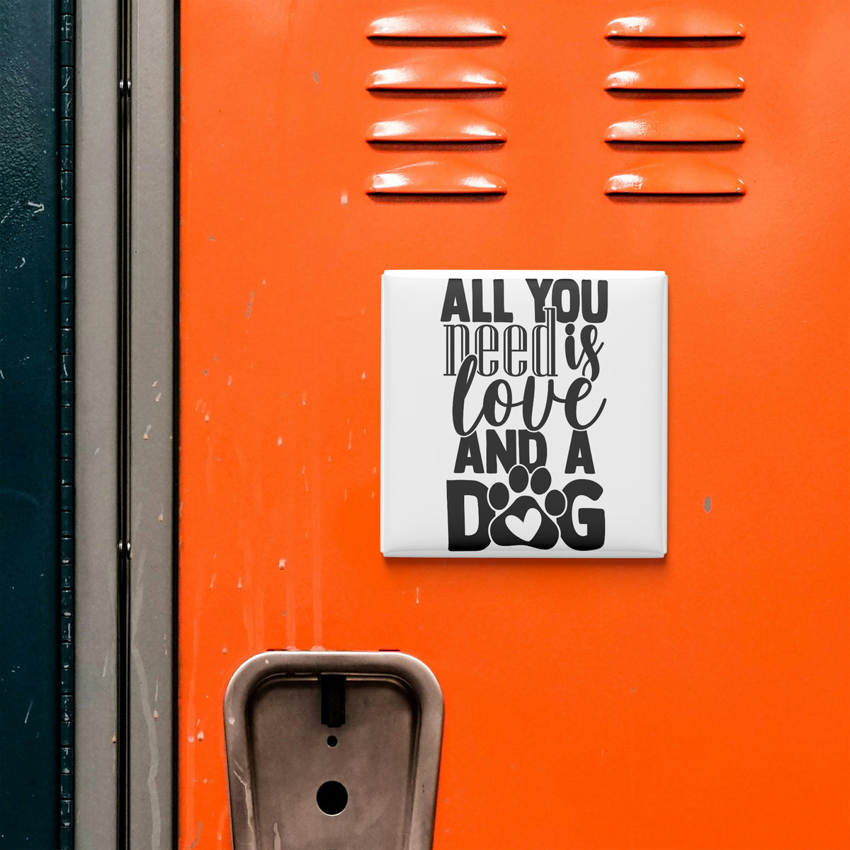 a vibrant orange surface with a white square magnet that reads "All you need is love and a dog".