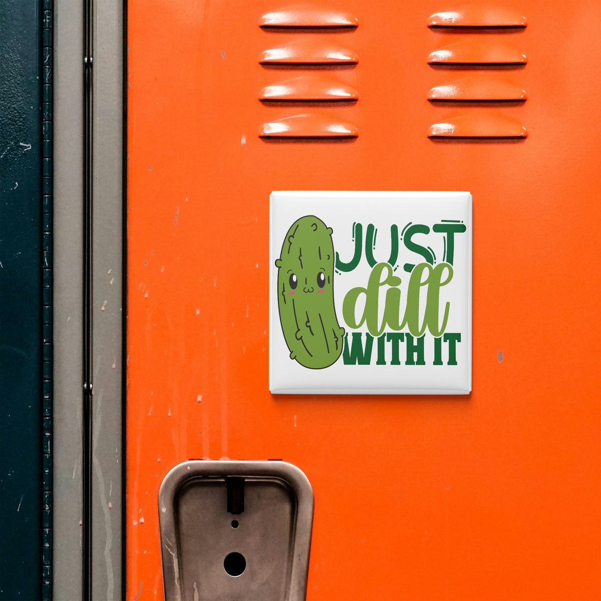 a sticker with a cartoon pickle and the text "Just dill with it" on an orange surface.