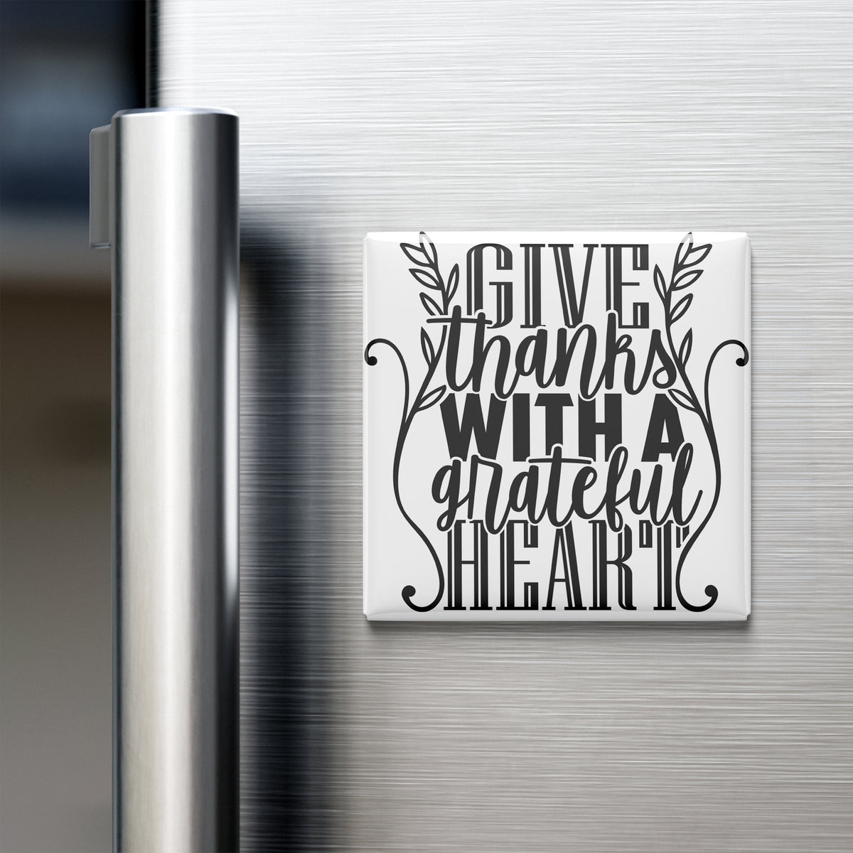 A white refrigerator magnet with the text "GIVE thanks with a grateful heart" written in a decorative font.