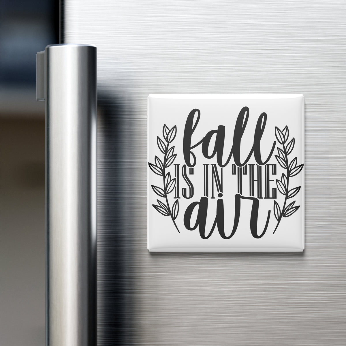 a refrigerator with a magnet that says "fall is in the air".