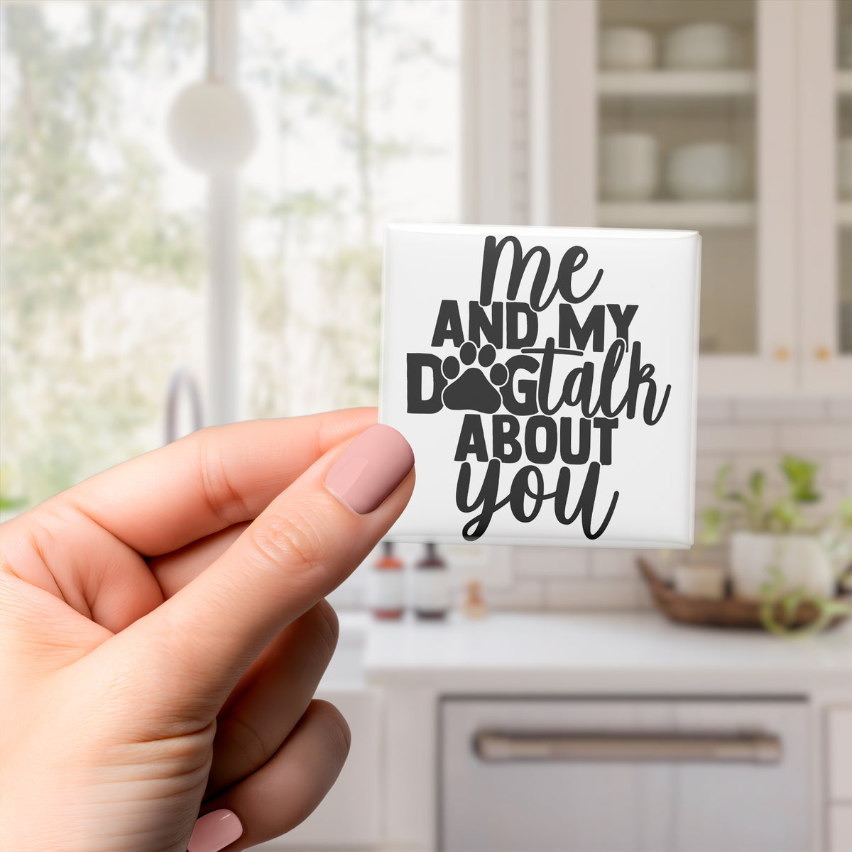 A hand holding a small white object with black text that says "me and my dog talk about you".