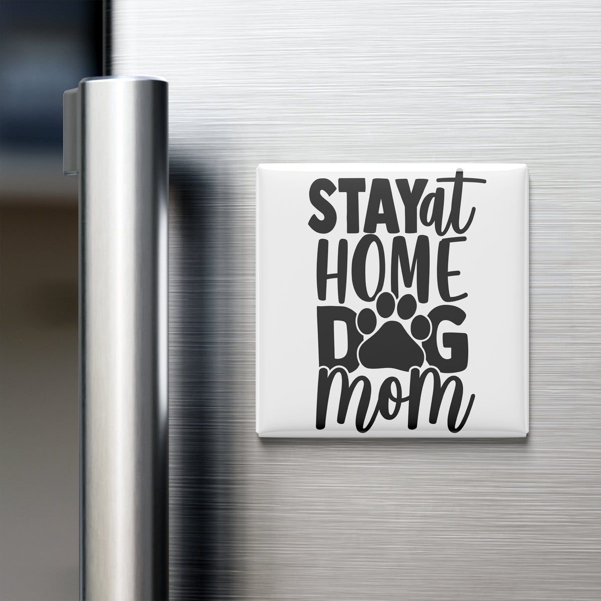 A white refrigerator magnet with the text "STAY AT HOME DOG MOM" printed on it.