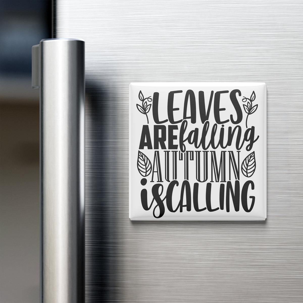 A white refrigerator magnet with the text "LEAVES ARE FALLING AUTUMN IS CALLING" printed on it.