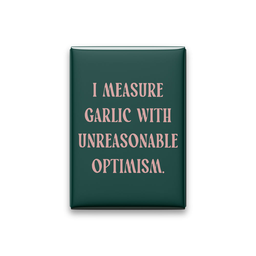 “I measure garlic with unreasonable optimism.” spruce quote magnet on white