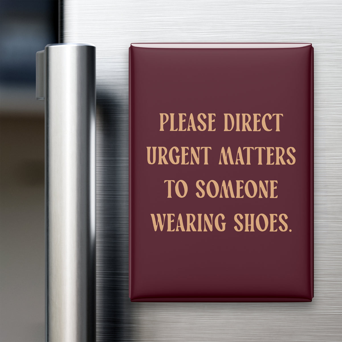 “Please direct urgent matters to someone wearing shoes.” quote magnet displayed on a refrigerator