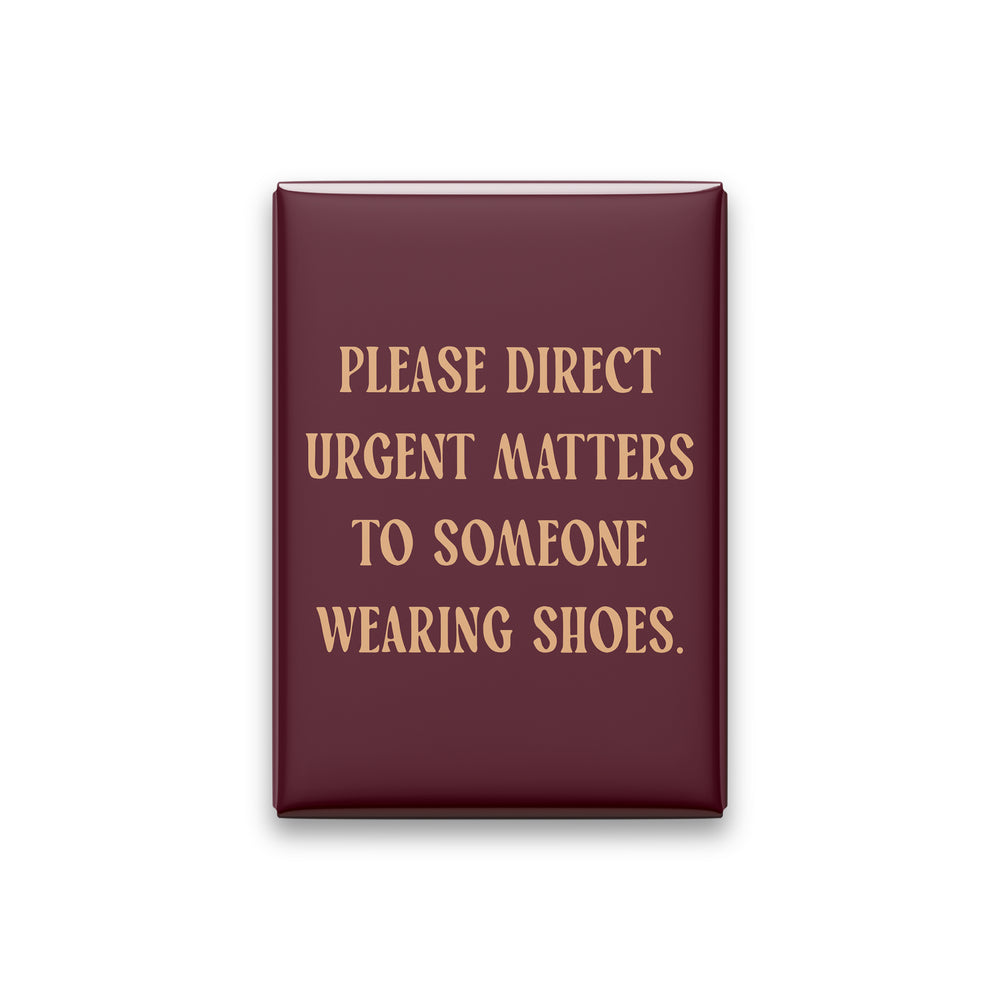 “Please direct urgent matters to someone wearing shoes.” oxblood quote magnet on white