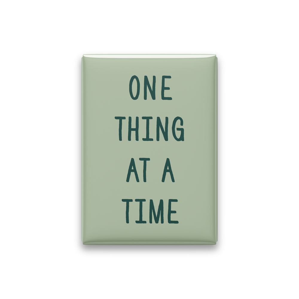 One Thing at a Time magnet in Spruce lettering on a Sage background, shown on white