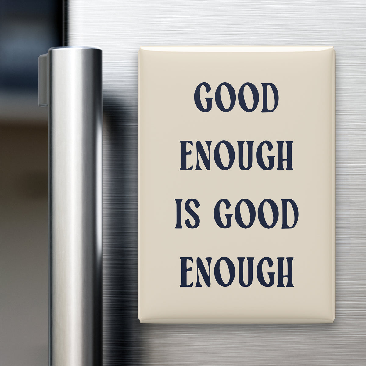 Good Enough Is Good Enough magnet in Midnight lettering on a Parchment background, displayed on a refrigerator
