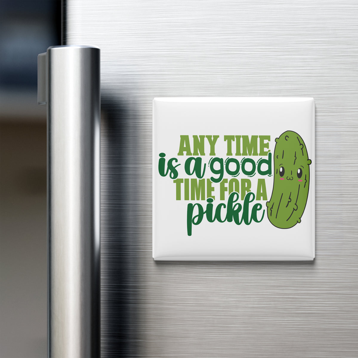 A white refrigerator magnet with a green pickle and the text "Any time is a good time for a pickle" printed on it.