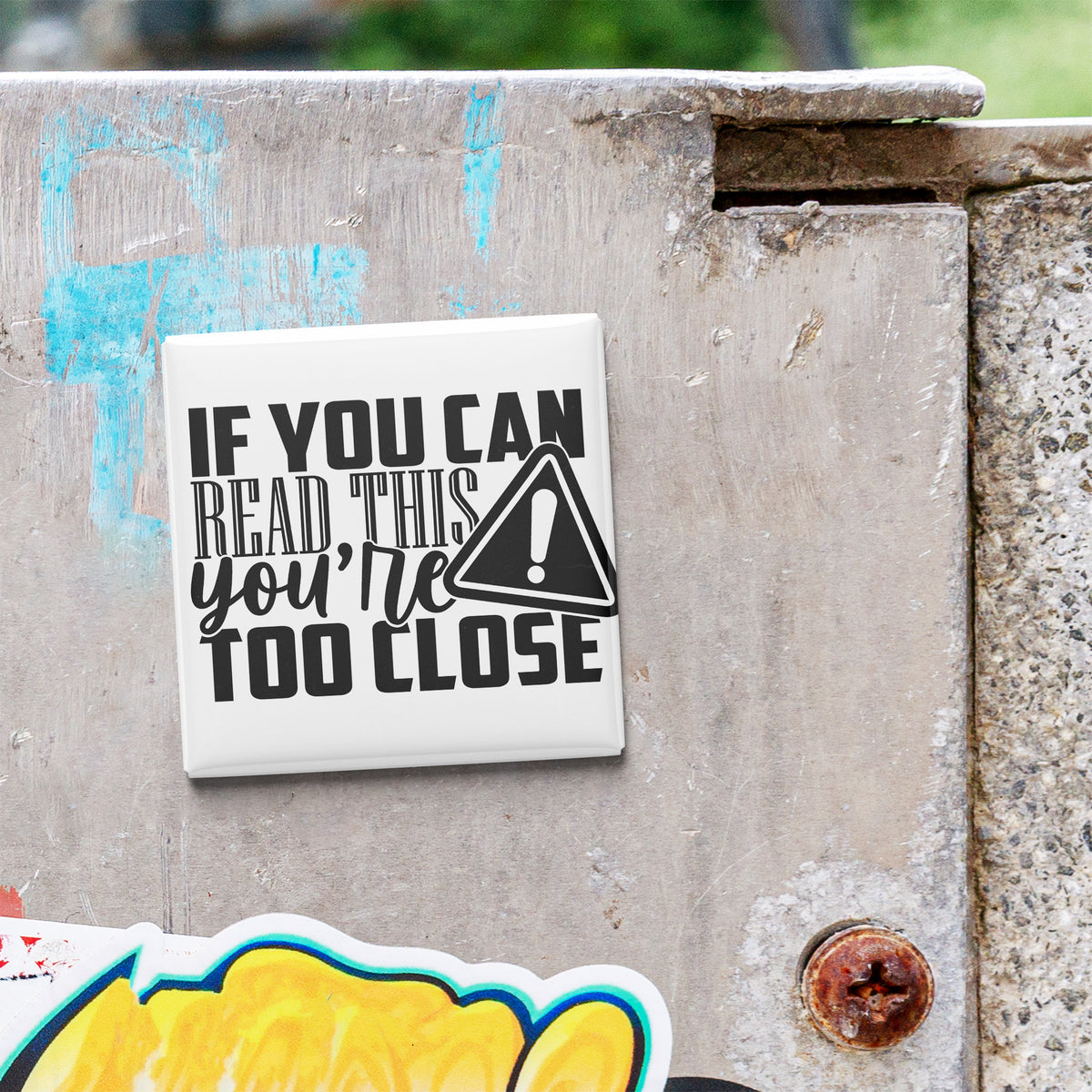a sticker with the text "If you can read this you're too close" on a metal surface.