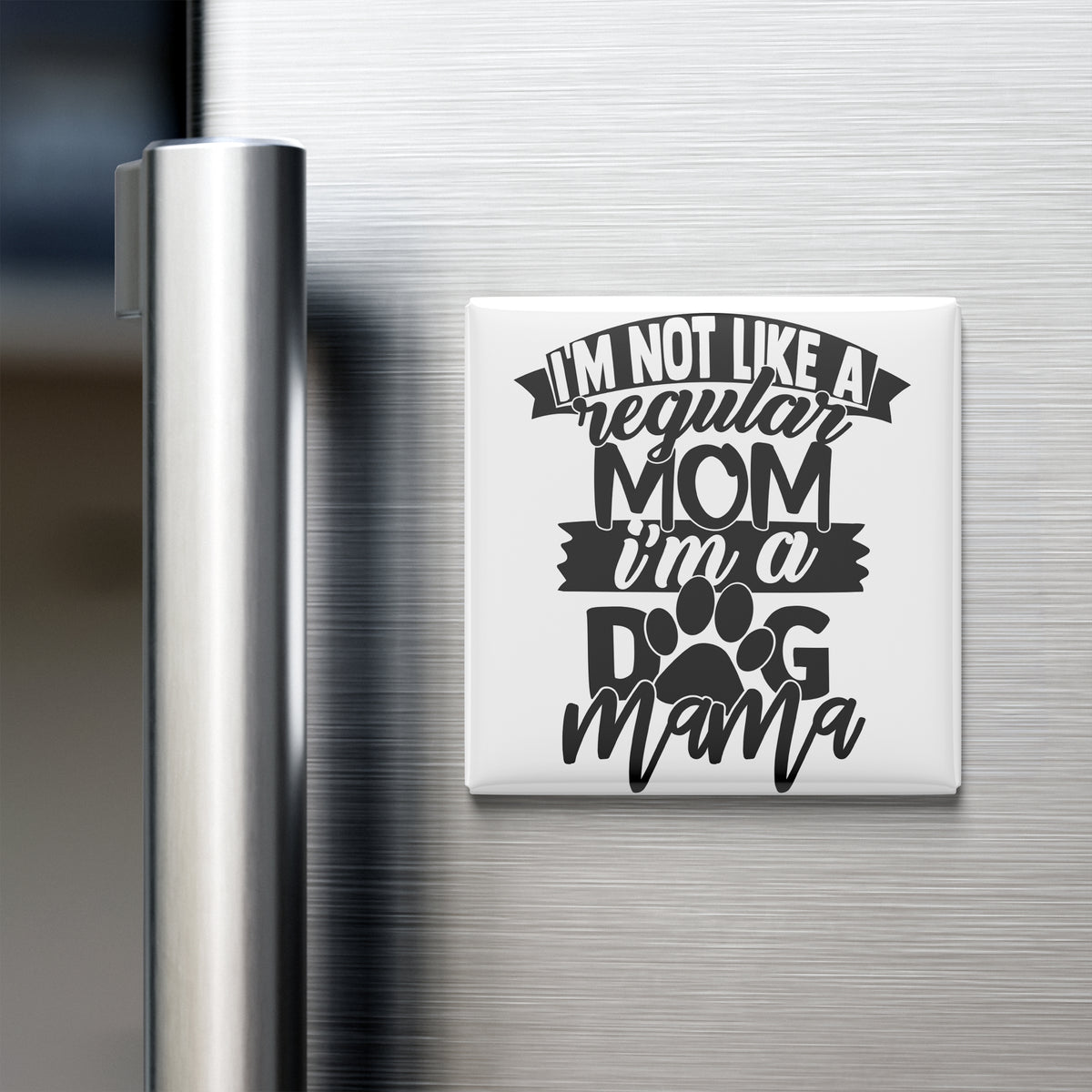 A white refrigerator magnet with the text "I'M NOT LIKE A REGULAR MOM I'M A DOG MAMA" printed on it.