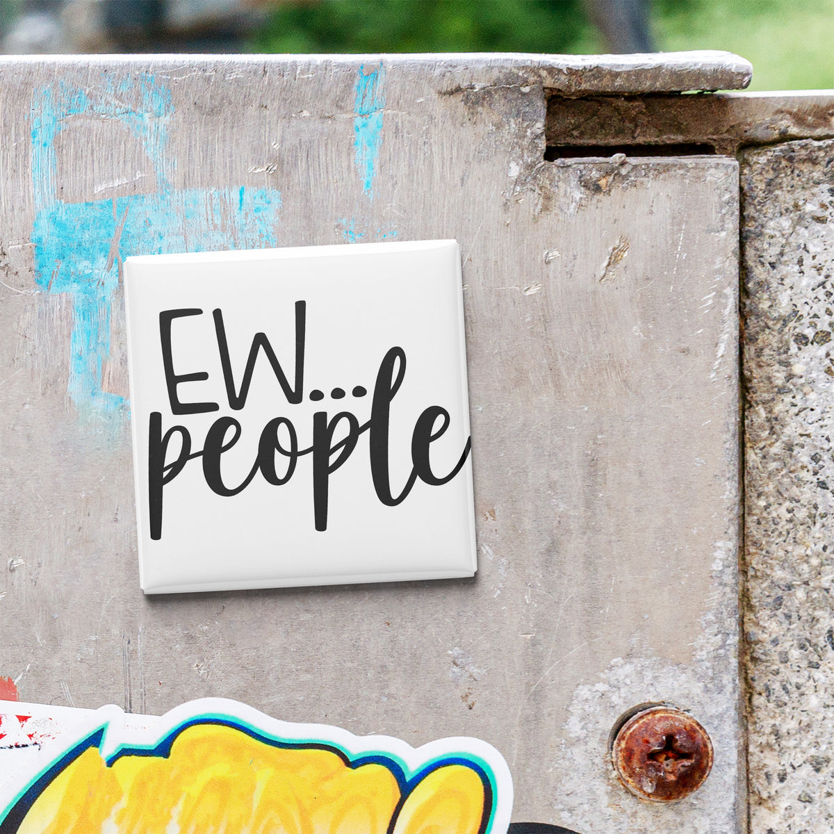 a white square magnet with the text "EW... people" written on it, which is attached to a weathered concrete surface.