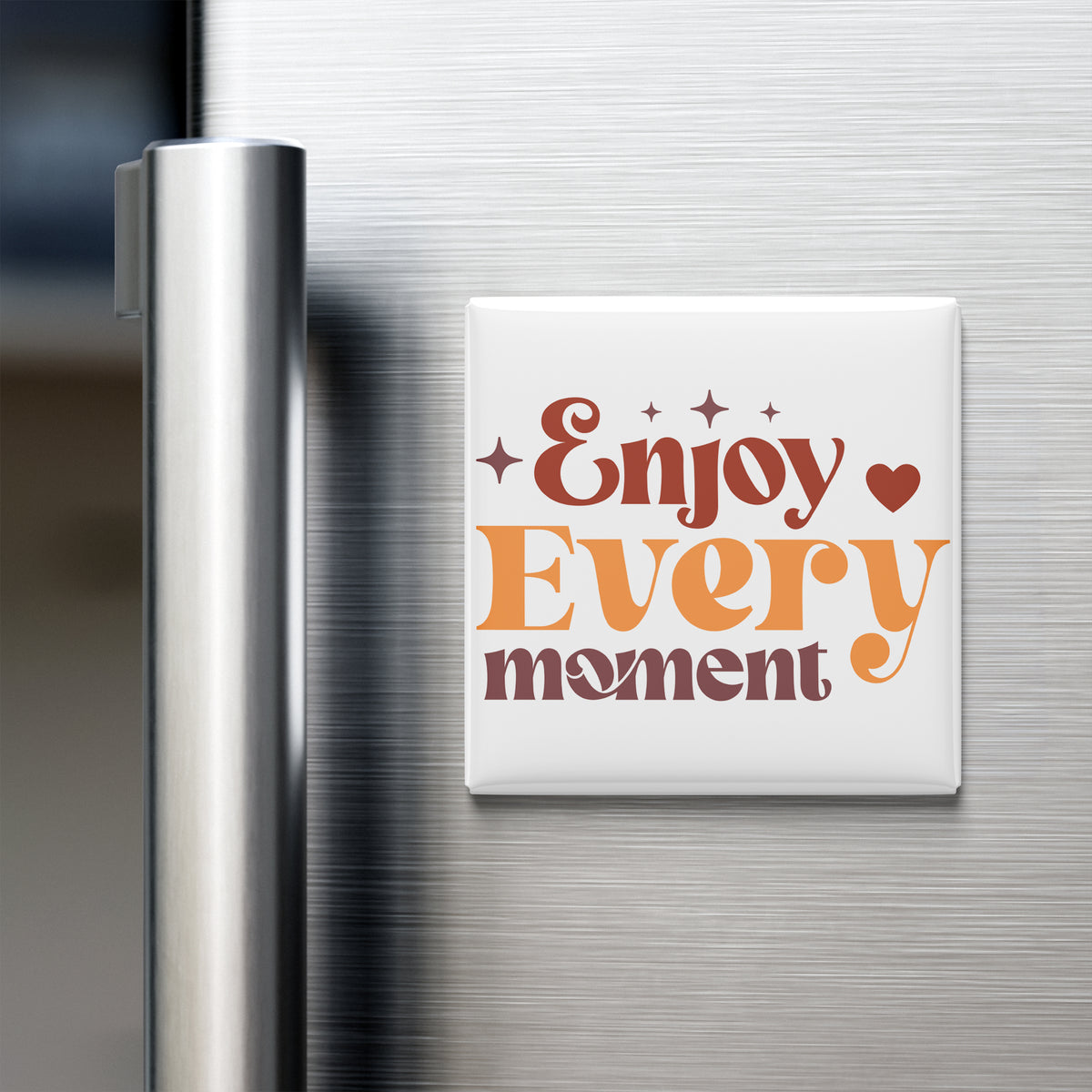A white refrigerator magnet with the text "Enjoy Every moment" in orange and brown colors.