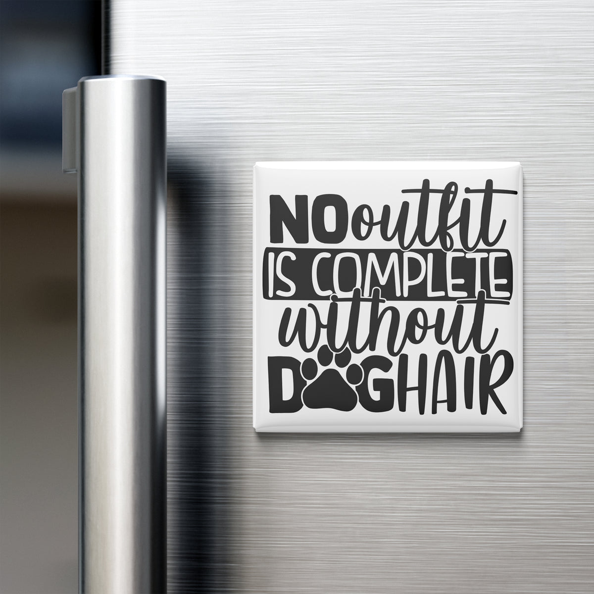 A white refrigerator magnet with black text that reads "NO outfit is complete without dog hair".