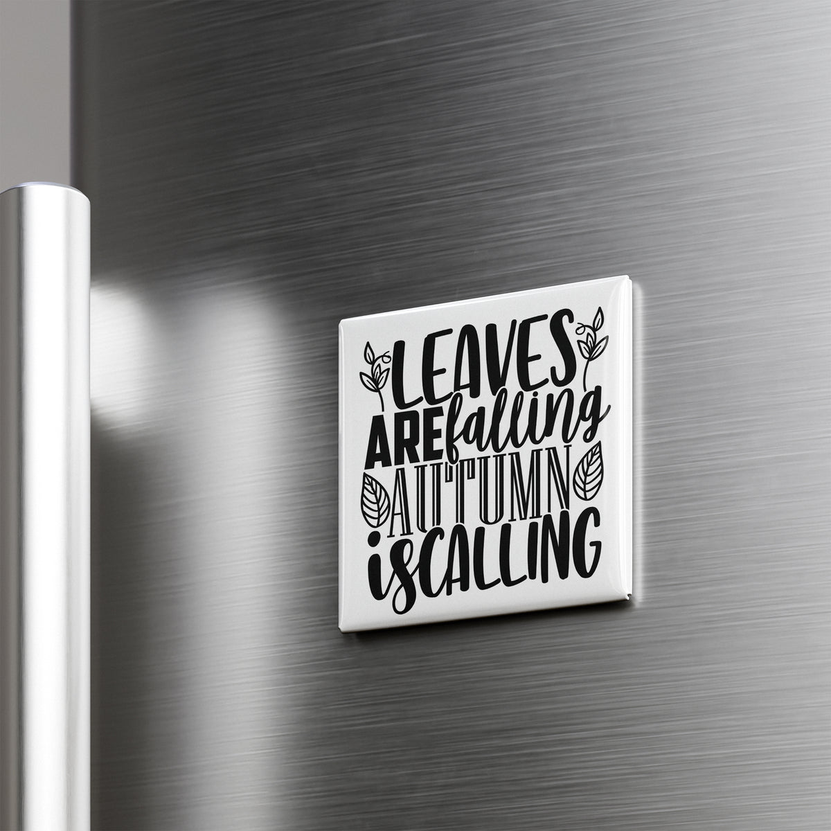 A white square magnet with black text that says "LEAVES AREFALLING AUTUMN IS CALLING" is mounted on a metallic surface.