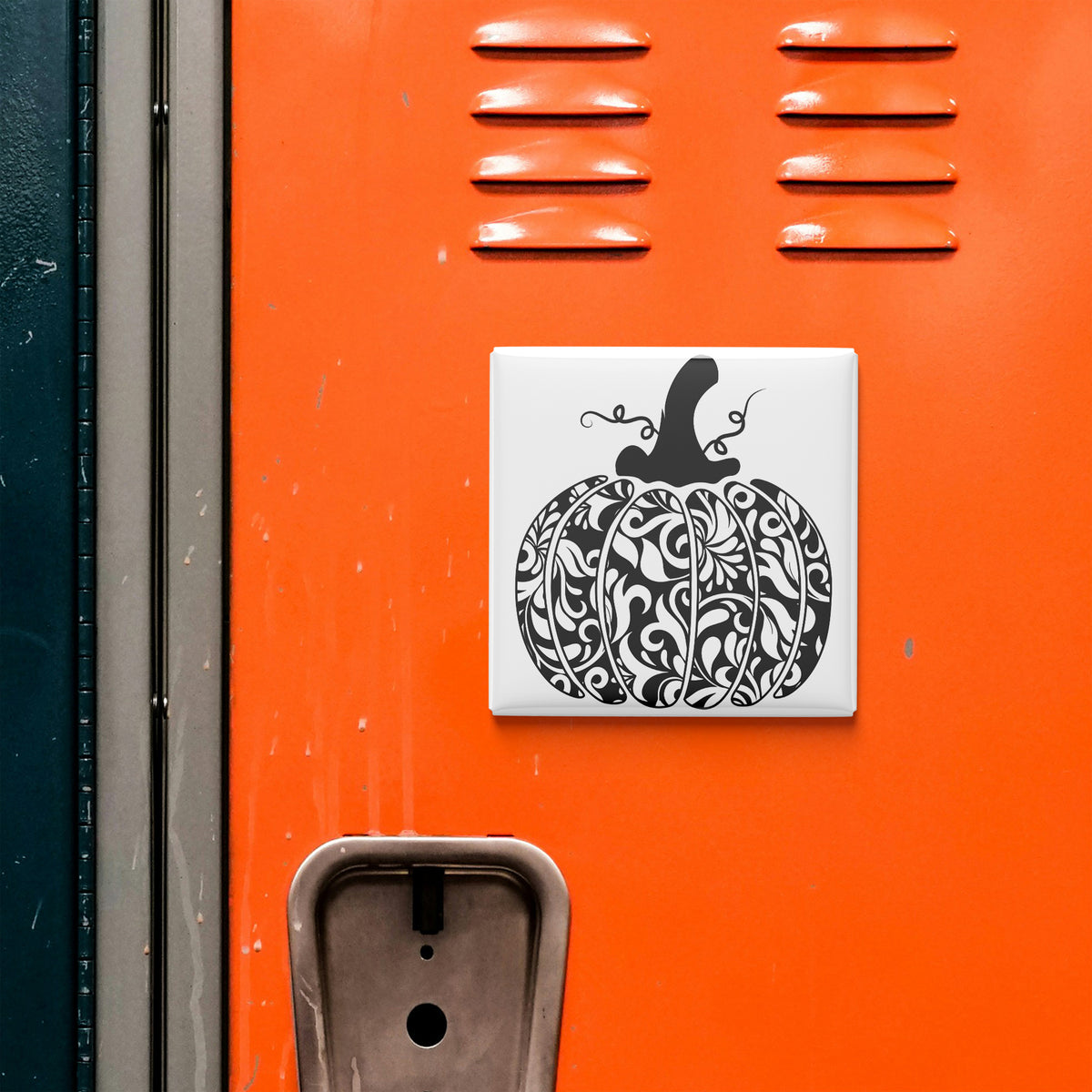 a vibrant orange wall with a decorative black and white pumpkin design on it.