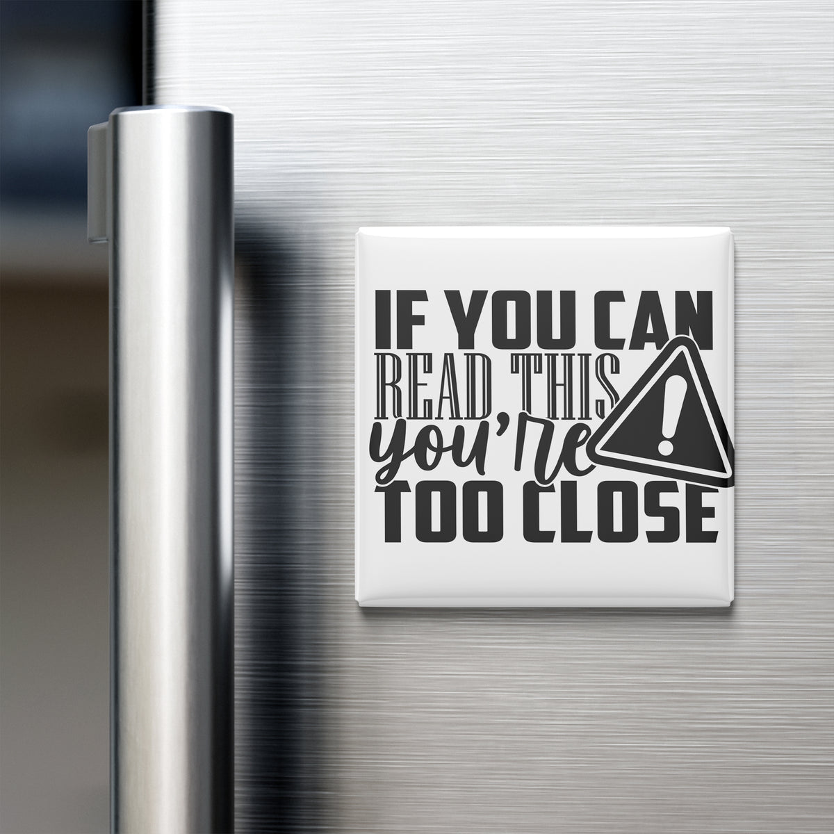 a refrigerator with a white magnet on its surface that contains the text "IF YOU CAN READ THIS YOU'RE TOO CLOSE".