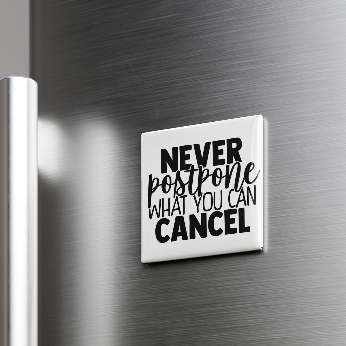 a white square magnet with the text "NEVER postone what you can cancel" on it, which is attached to a metallic surface, likely a refrigerator door.