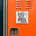 a vibrant orange wall with a sticker that reads "fall days are fun days" and includes an illustration of a pumpkin and an acorn.