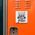a vibrant orange surface with a white sticker that reads "DOG HAIR is my glitter" in bold black text.