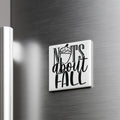 A white square magnet with the text "NOTS ABOUT FALL" on it, which is mounted on a metallic surface.