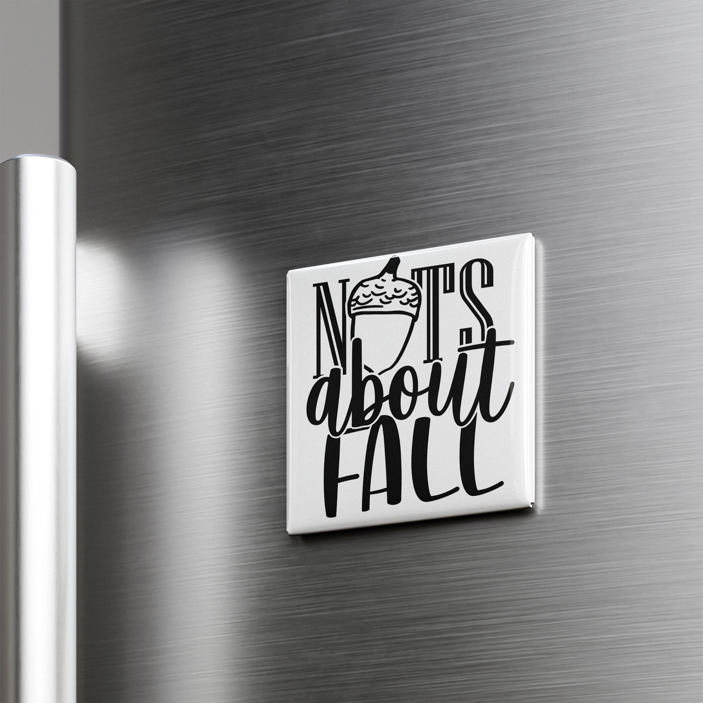 A white square magnet with the text "NOTS ABOUT FALL" on it, which is mounted on a metallic surface.