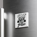 A white magnet with the text "CAT HAIR IS MY GLITTER" on it is attached to a metallic surface.