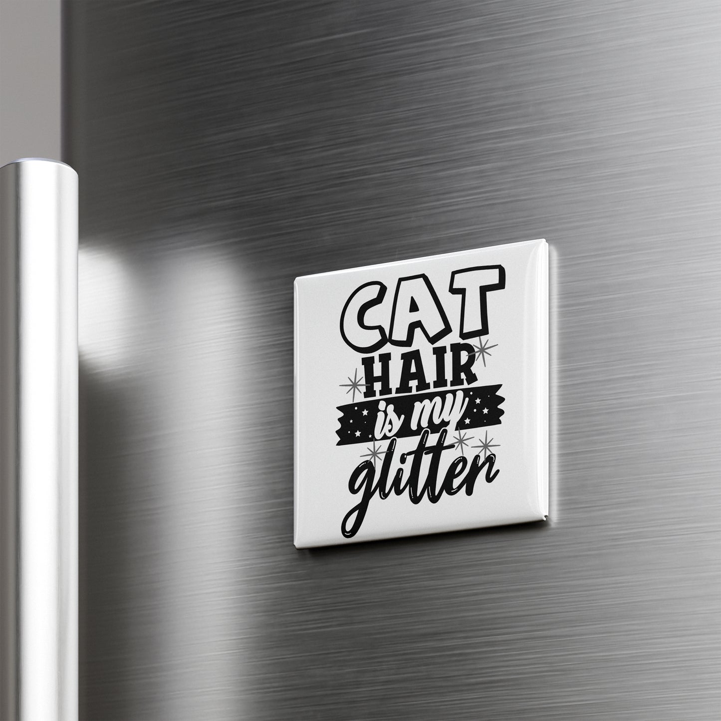 A white magnet with the text "CAT HAIR IS MY GLITTER" on it is attached to a metallic surface.