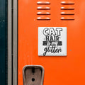 a vibrant orange wall with a white square sticker that reads "CAT HAIR is my glitter" in bold black text.