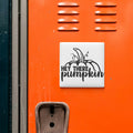 a close-up view of an orange surface with a white sticker or decal that says "HEY THERE PUMPKIN" in black text.
