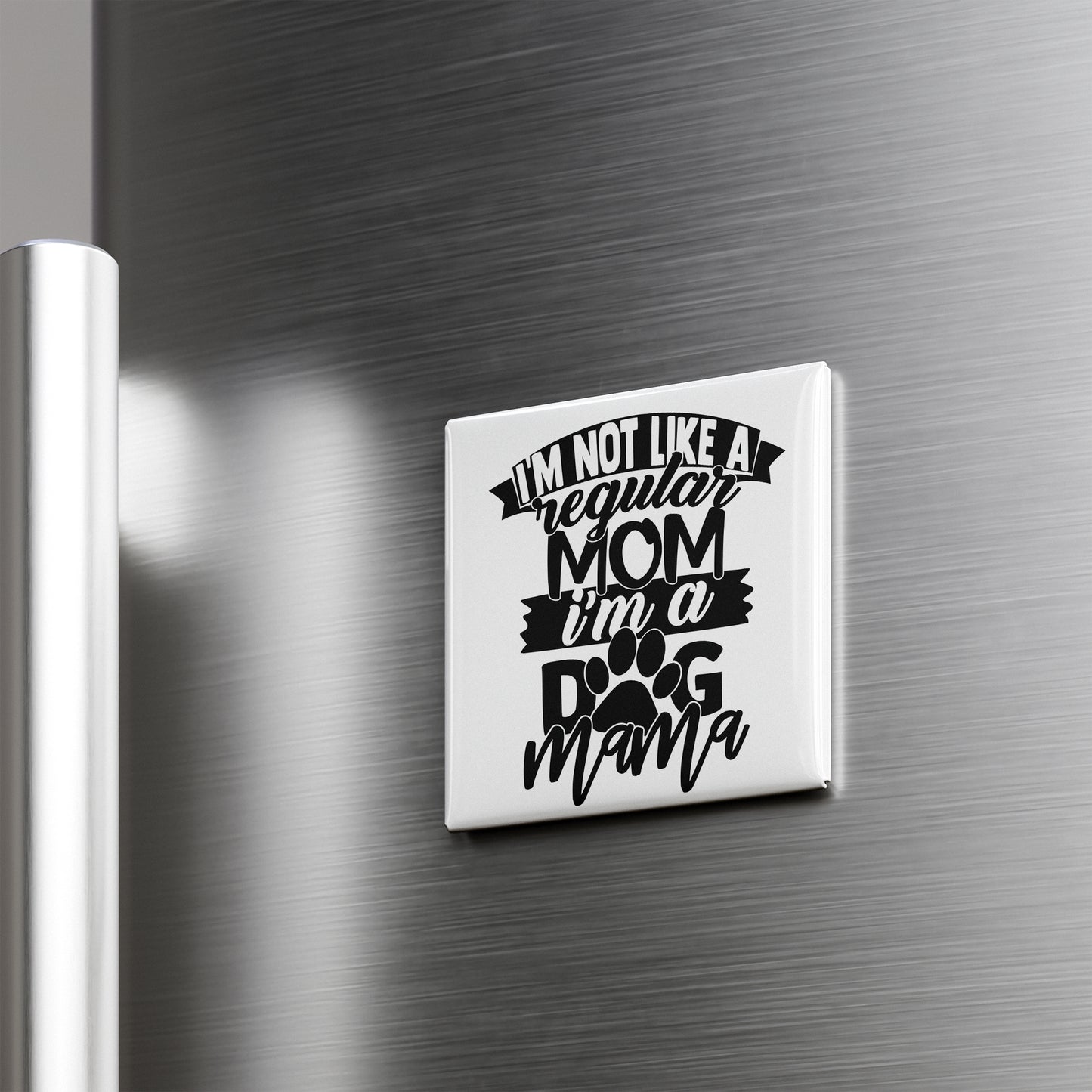 A humorous fridge magnet with the text "I'M NOT LIKE A REGULAR MOM I'M A DOG MAMA" printed on it.