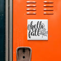 a vibrant orange wall with a white sign that reads "Hello fall" and a leaf graphic.