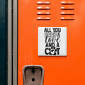 a vibrant orange surface with a white sign that reads "All you need is love and a dog" in bold black text.