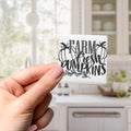 A hand holding a small square magnet with the text "FARM FRESH PUMPKINS" written on it.