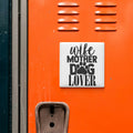 a close-up of an orange surface with a white sign that reads "wife mother dog lover" in black text.