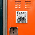 a sticker with a message on an orange surface, which reads "Free Hugs Just Kidding Don't Touch Me".
