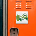 a vibrant orange wall with a white sign that reads "Pickle queen" in green text.
