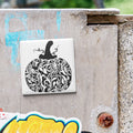 a decorative pumpkin sticker on a concrete surface.