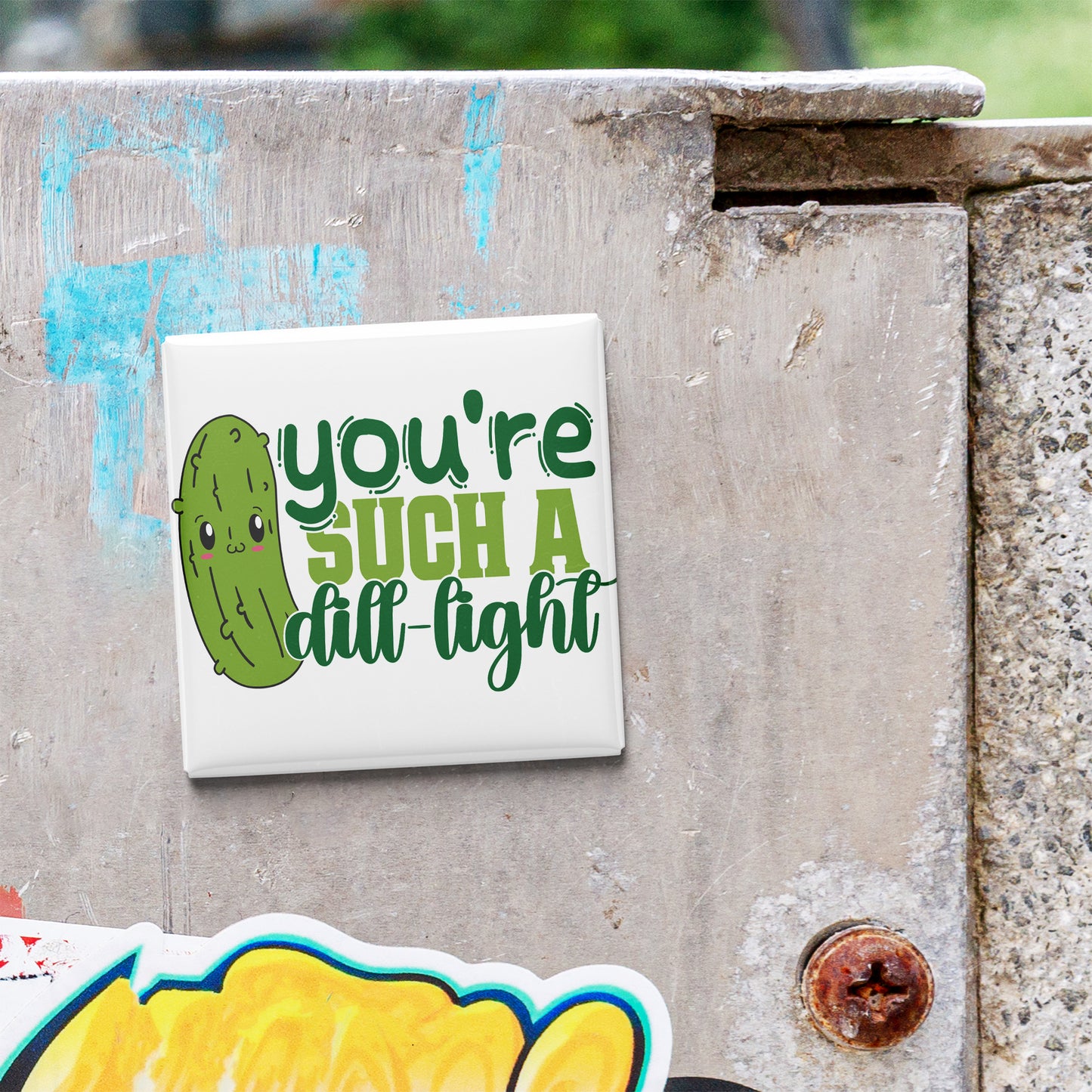 A sticker with a cartoon pickle and the text "you're such a dull light" is attached to a concrete surface.